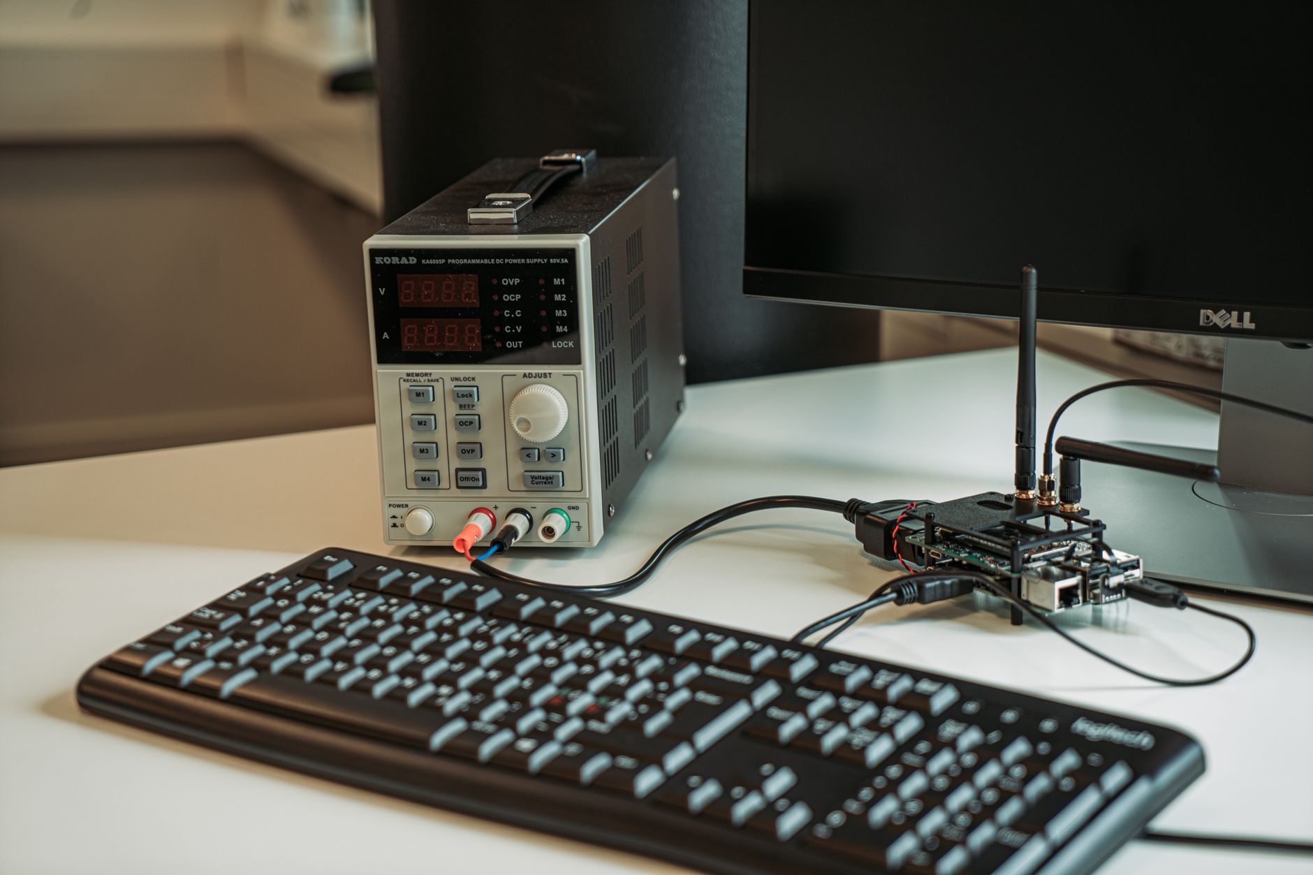 A high-tech desktop setup featuring a power programmer, computer keyboard, and monitor