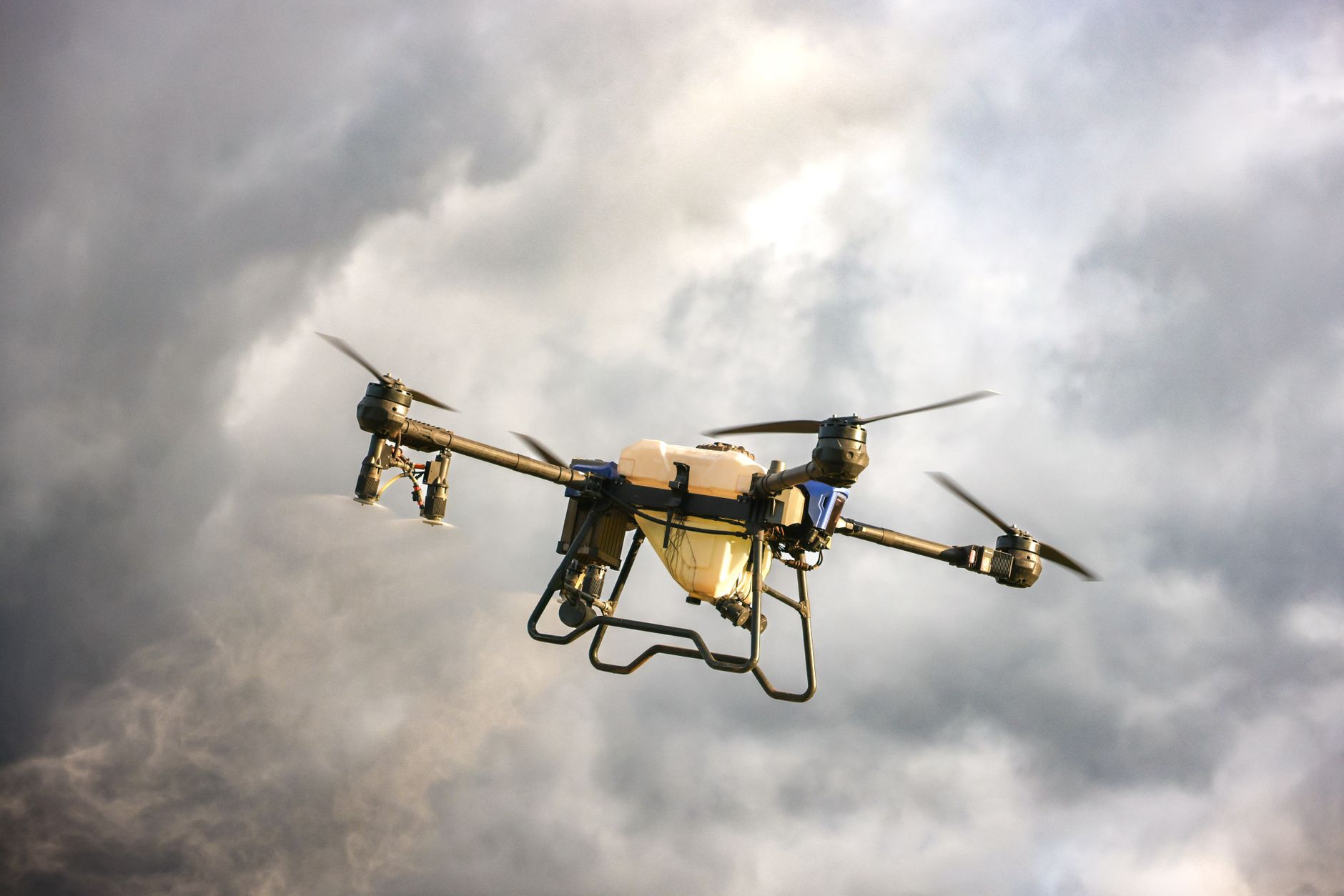 High-tech drone flying amidst dramatic cloudy skies, showcasing advanced technology.