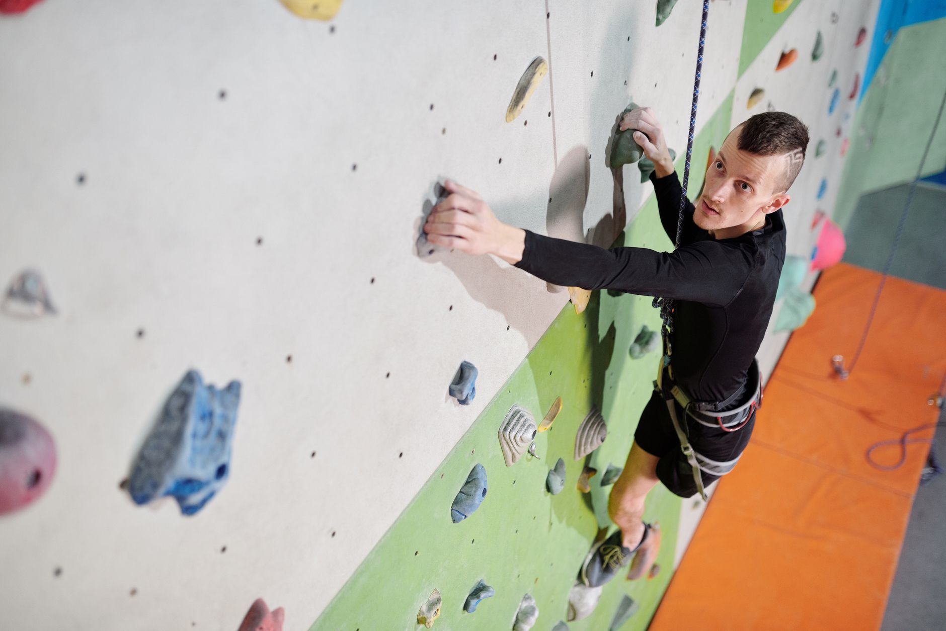 A determined climber with a prosthetic leg overcoming challenges on an indoor climbing wall.