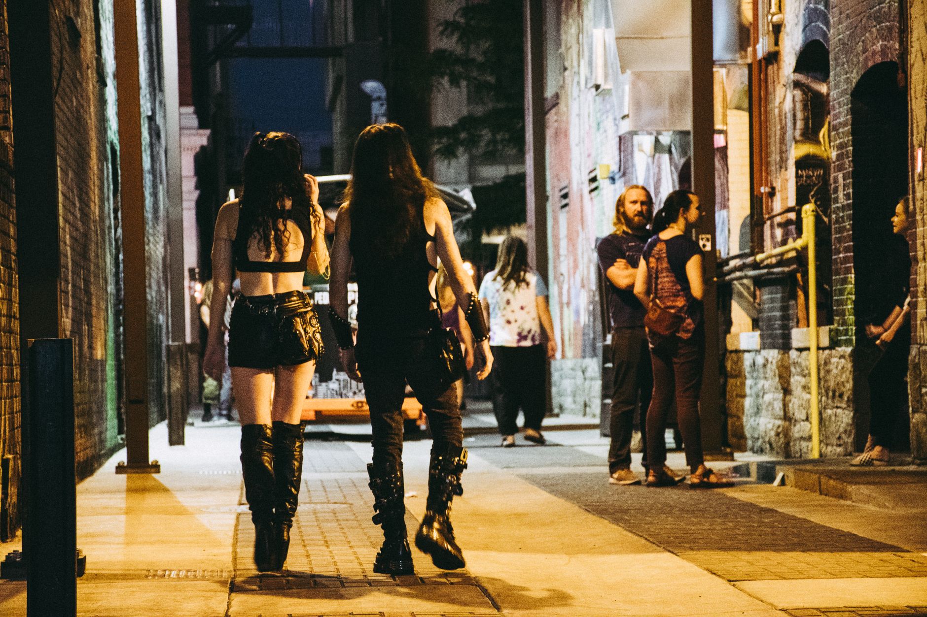 People in gothic attire walking on a city street at night — gothic glam fashion trend