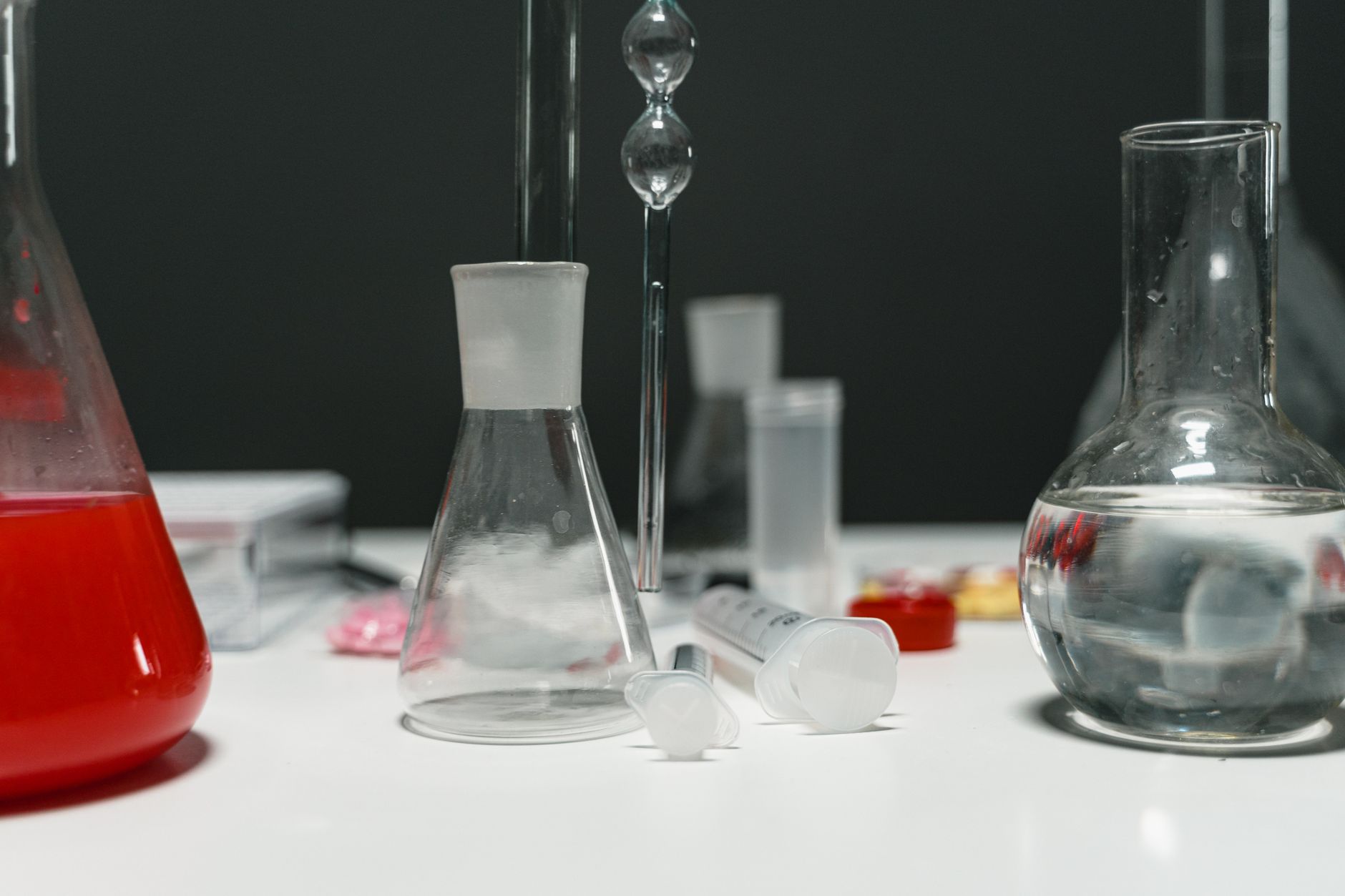 Close-up of lab equipment including syringes and beakers. Ideal for scientific themes.