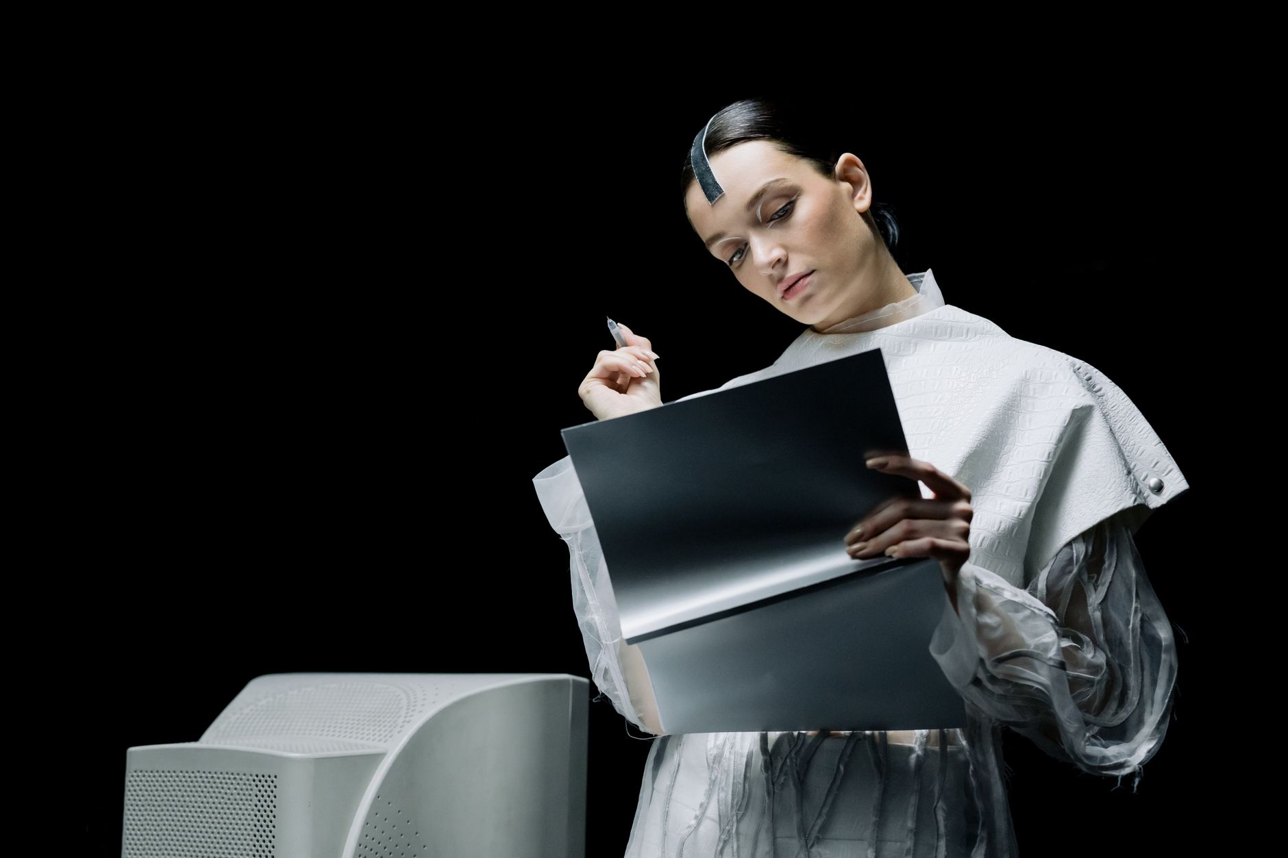 A female scientist with futuristic attire reviews notes in an advanced lab setting.