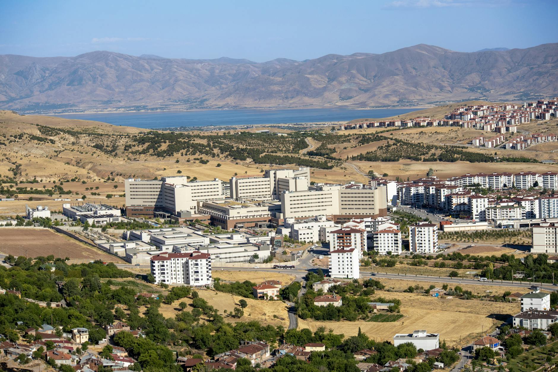 Stunning aerial photograph capturing the expansive cityscape of Elâzığ, Türkiye, with distant mountains.