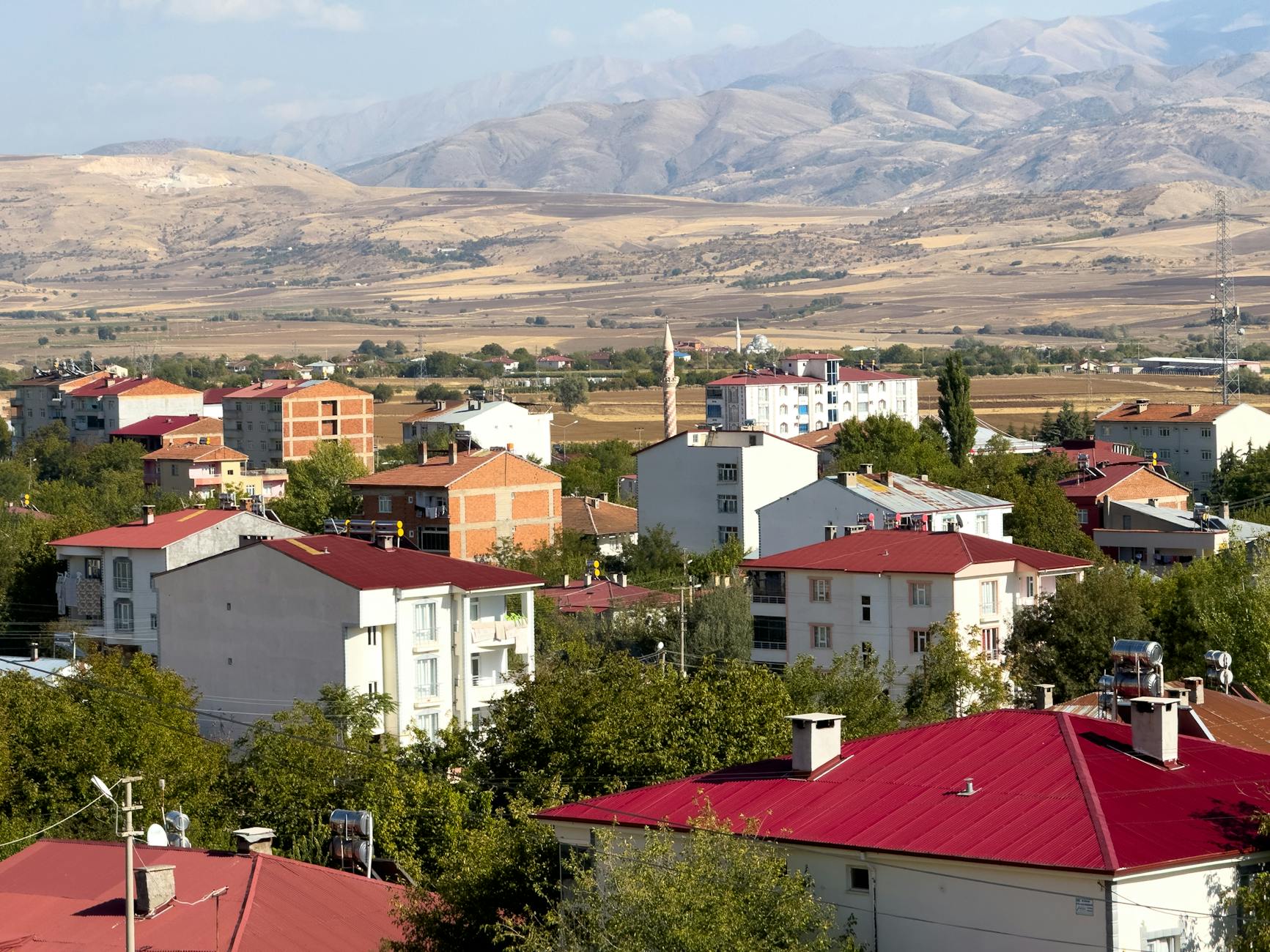 Panoramic view of Kovancılar town with red-roofed buildings against a backdrop of mountains in Elazığ, Türkiye.