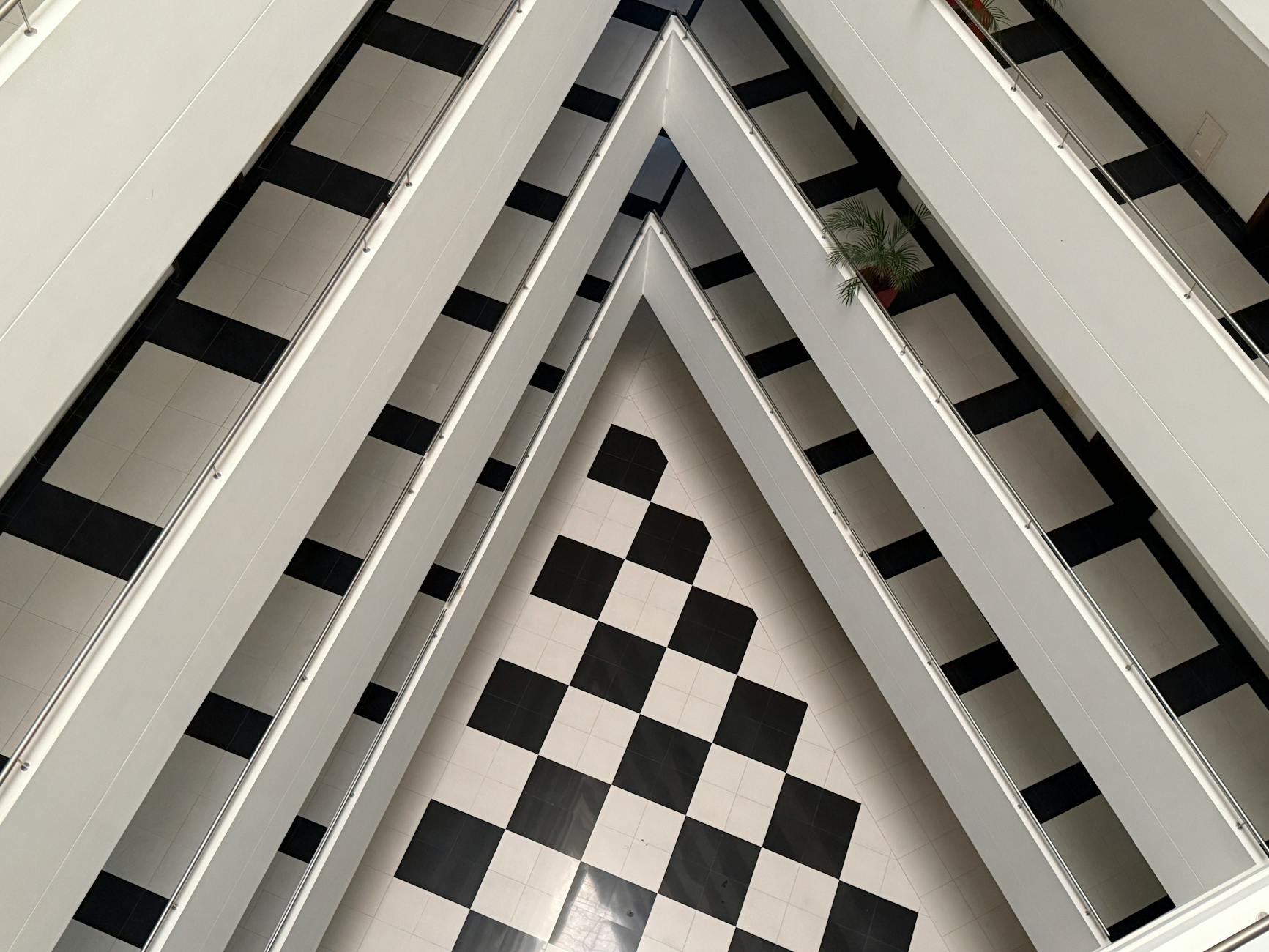 Aerial view of architectural interior with black and white checkered flooring.