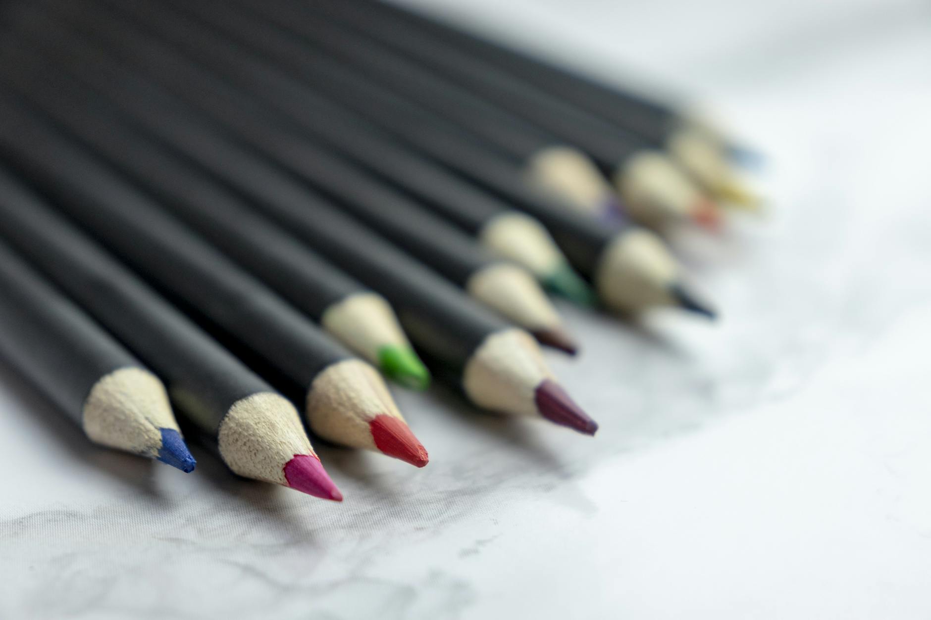 A detailed close-up of various multicolored sharpened pencils arranged in a row.