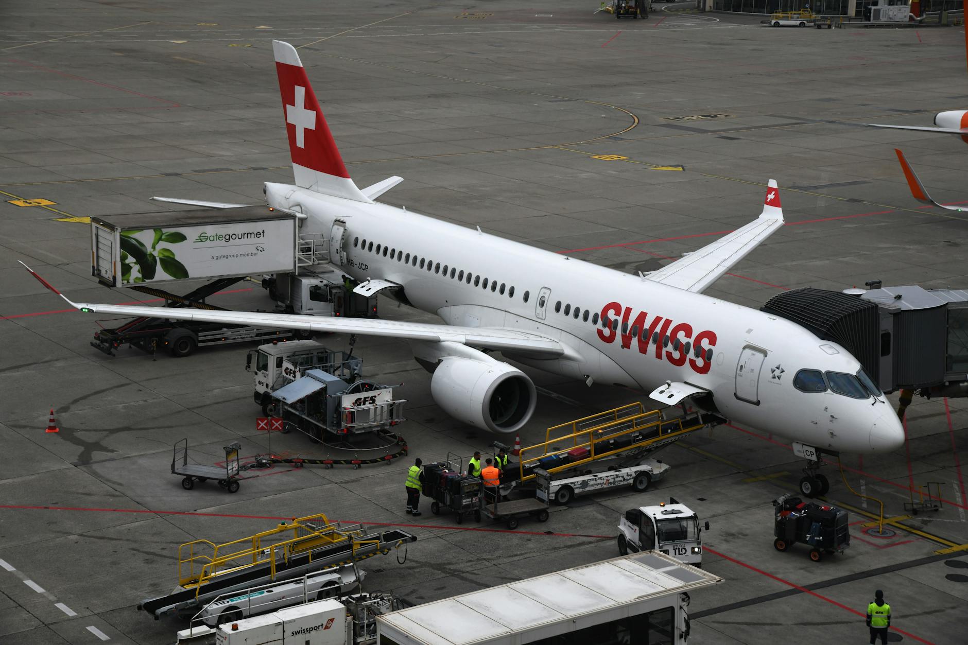 Swiss Airbus airplane being serviced on the tarmac of Geneva airport.