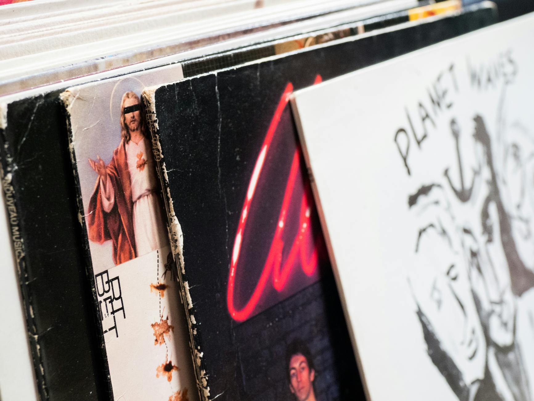 A close-up shot of vintage vinyl records in a shop, showcasing classic album covers.
