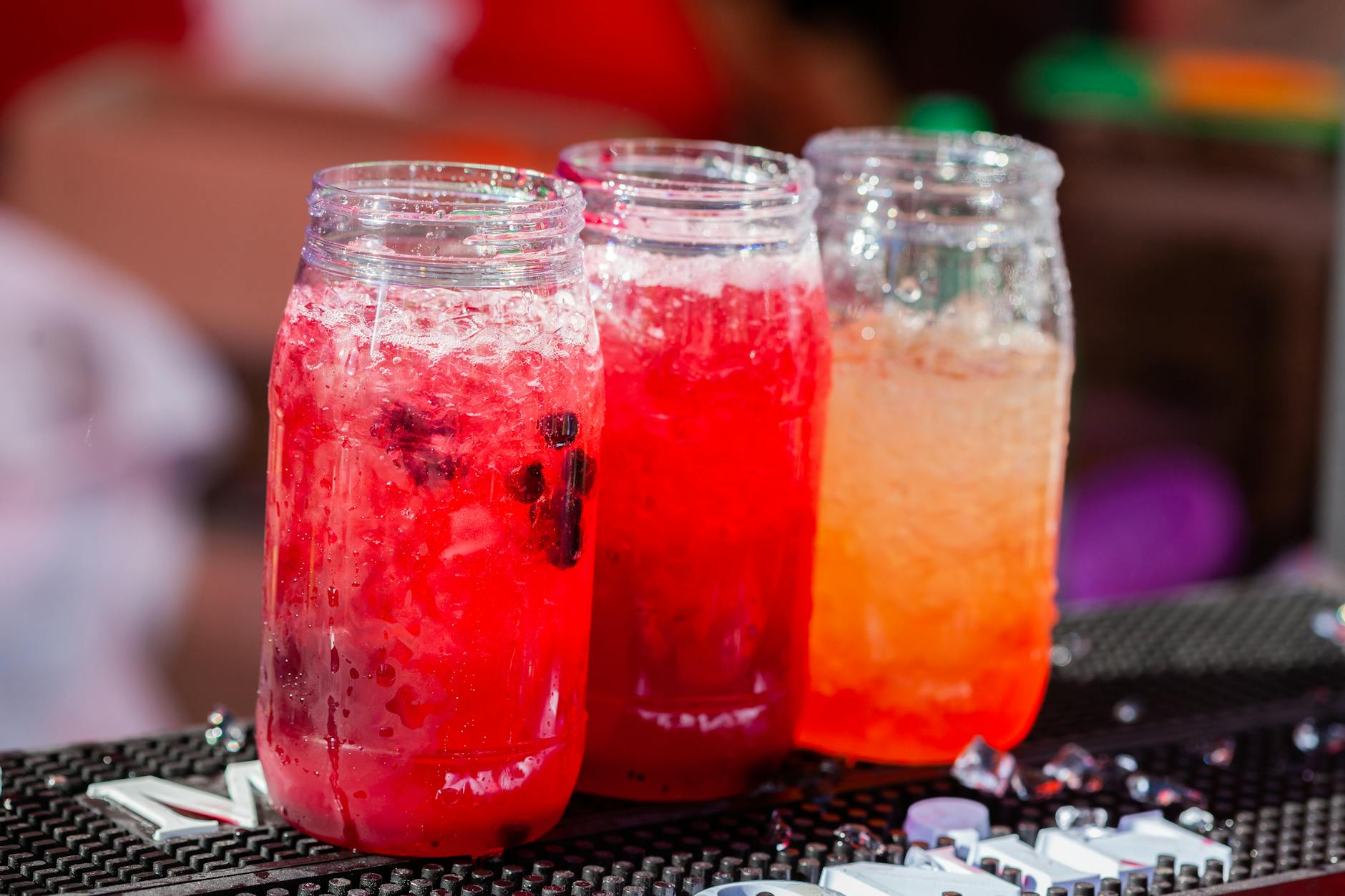 Three vibrant cocktails in glass jars, perfect for summer refreshment.