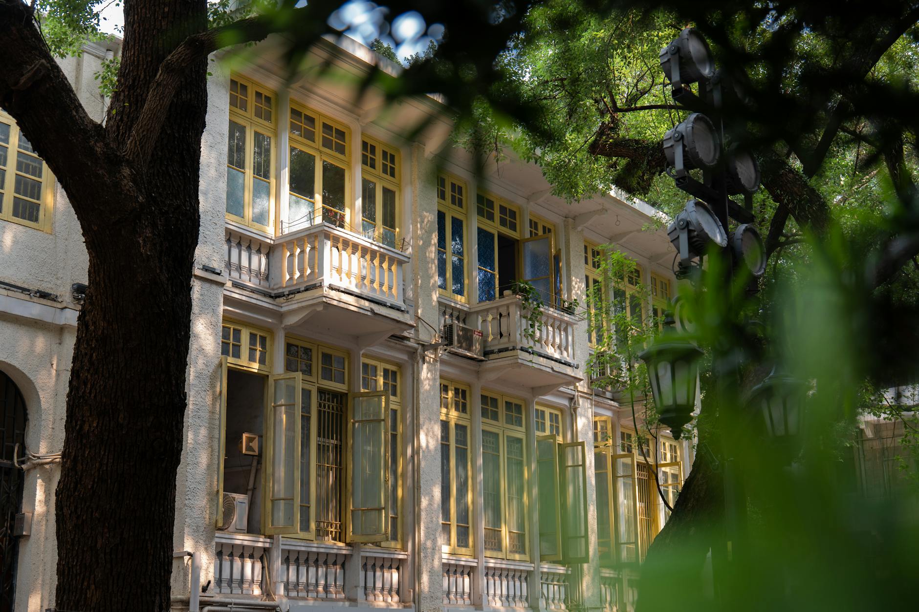 Charming historic building with yellow windows among lush greenery. Perfect for travel and architecture themes.