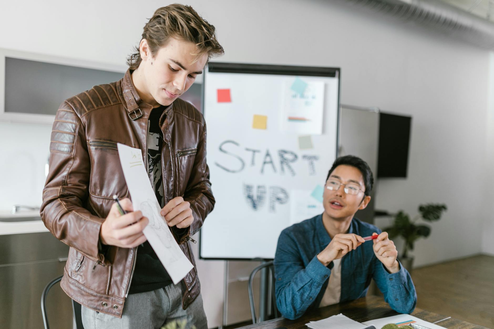 Two young men collaborating in a startup meeting with brainstorming session.