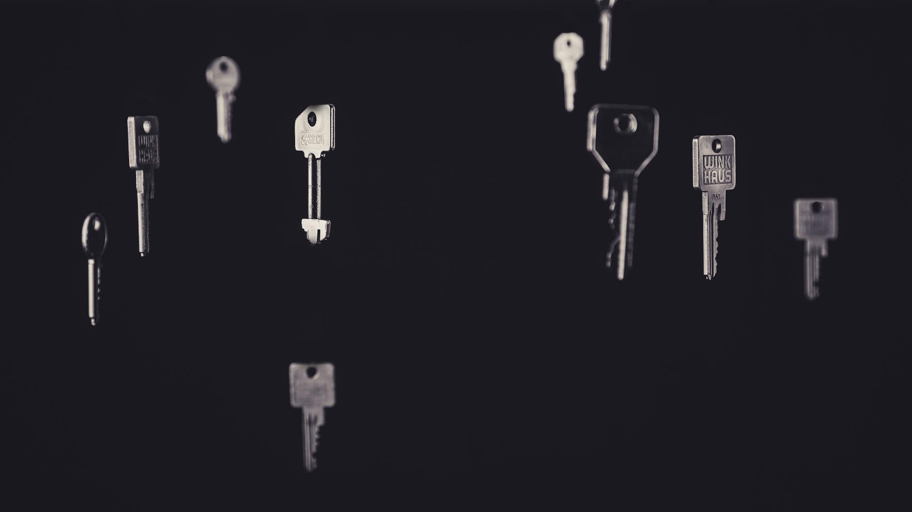Artistic display of floating metallic keys in a dark, minimalist setting.