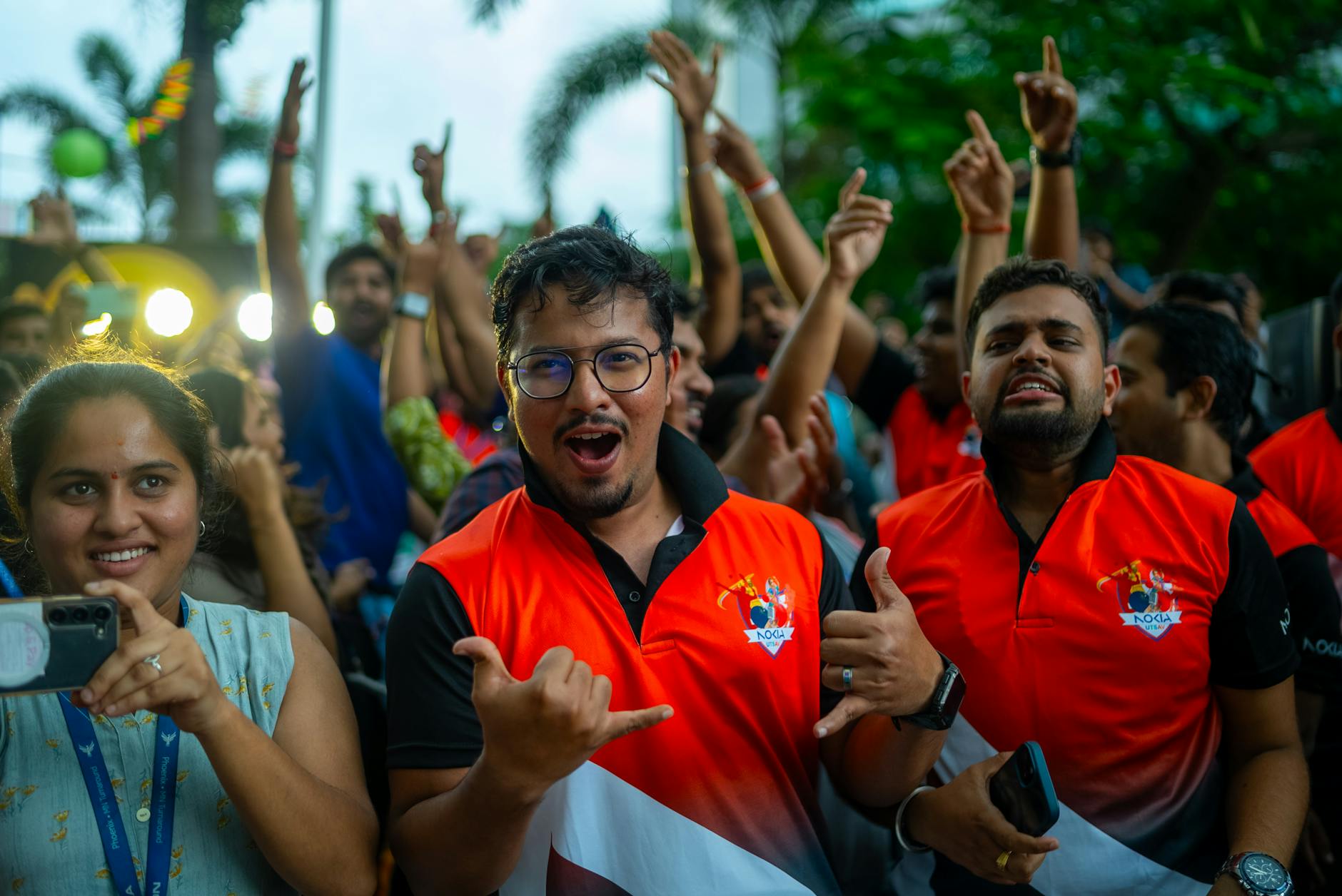 A lively crowd cheering energetically at an outdoor sports event. Vibrant and spirited atmosphere captured.