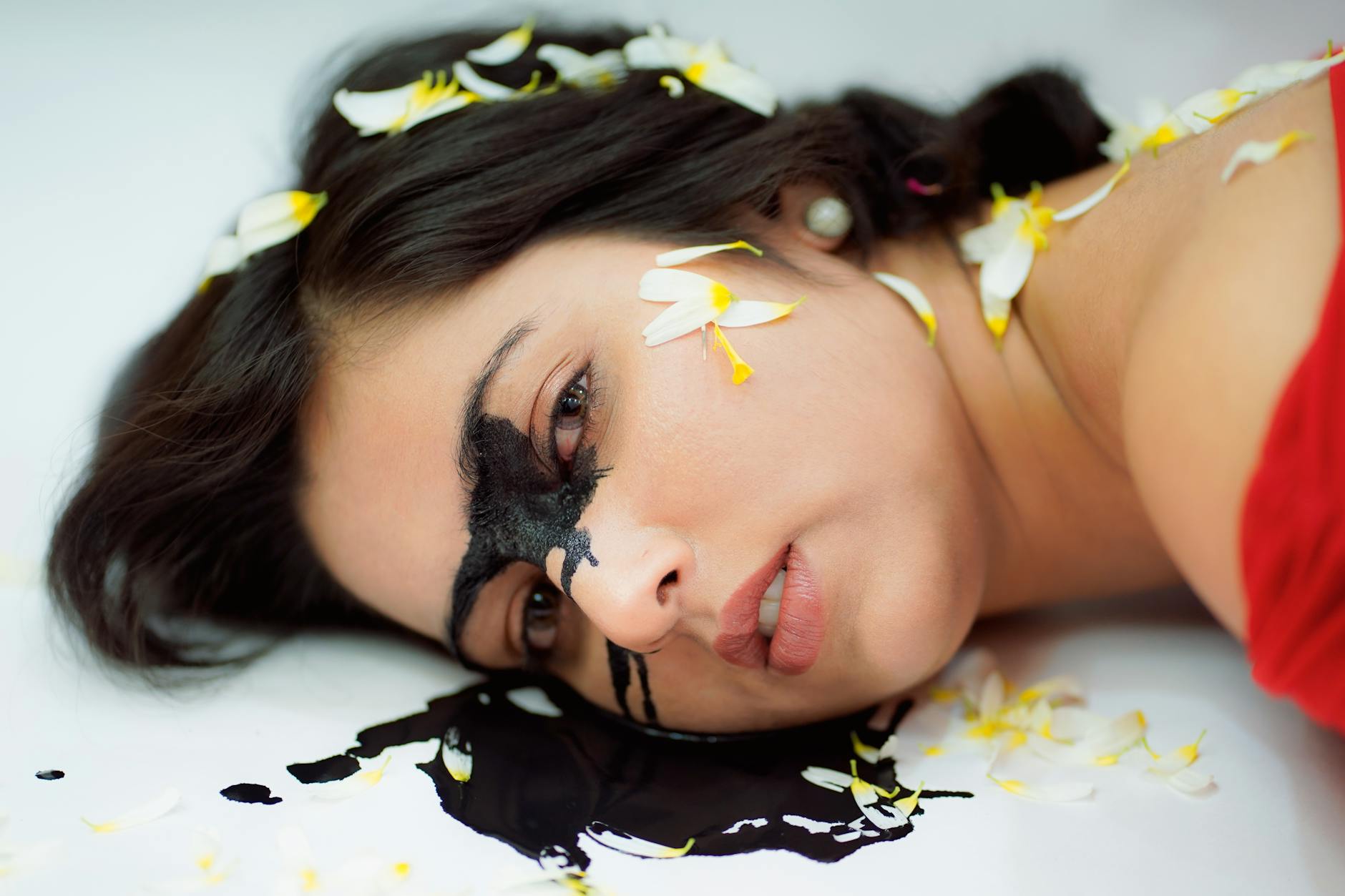 Creative portrait of a woman with flowers and paint for artistic photography.