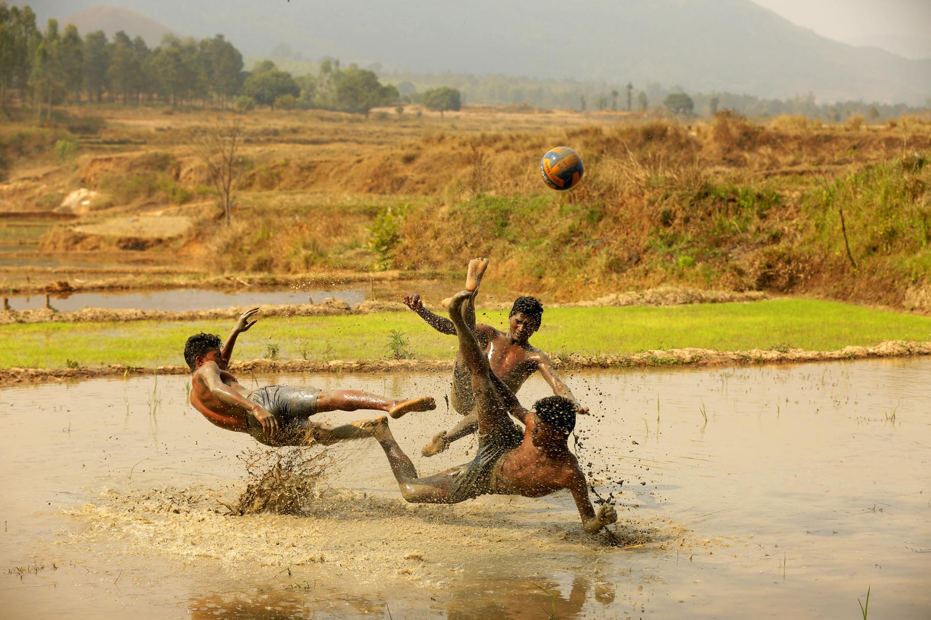 Young men playing a lively football game in muddy fields at Araku Valley.