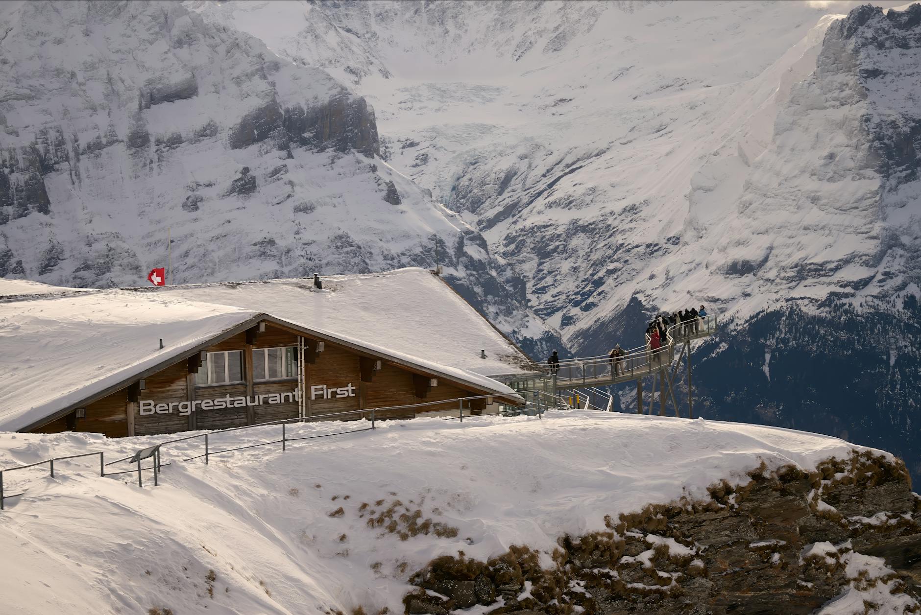 A breathtaking view of Bergrestaurant First in the Swiss Alps with snowy landscapes and scenic beauty.