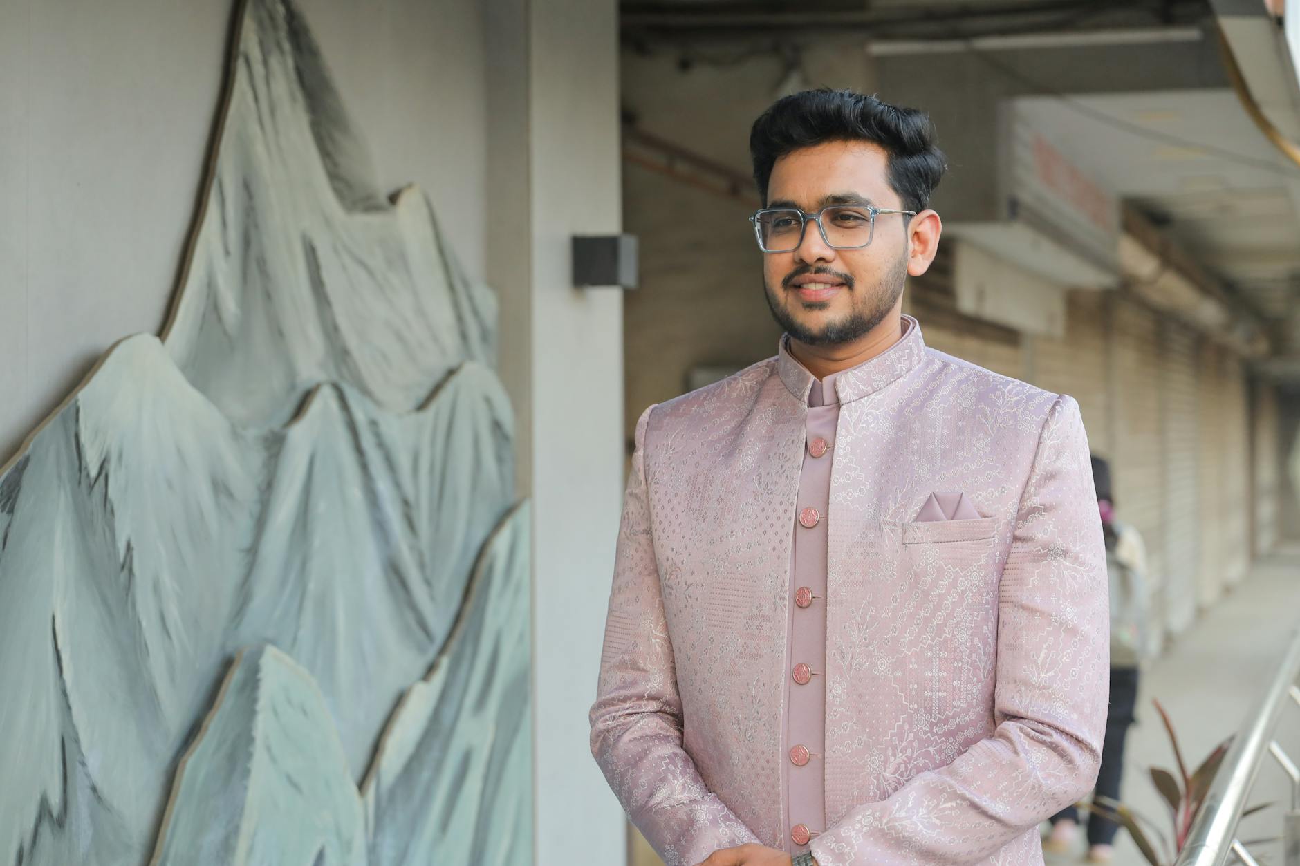 A young man poses in traditional Indian fashion wearing a stylish kurta.