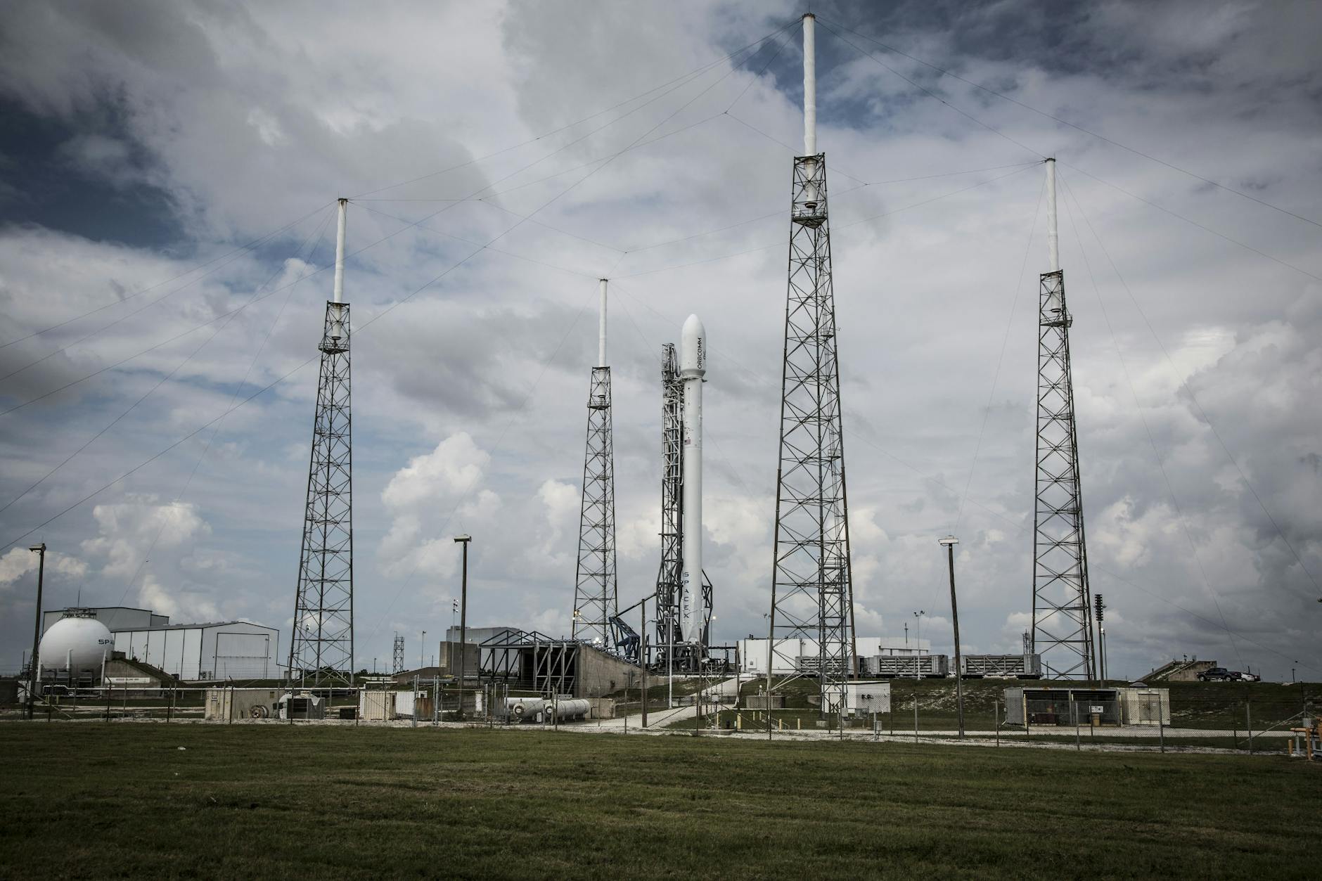 Industrial rocket launch pad with tall towers under a cloudy sky, perfect for technology and energy themes.