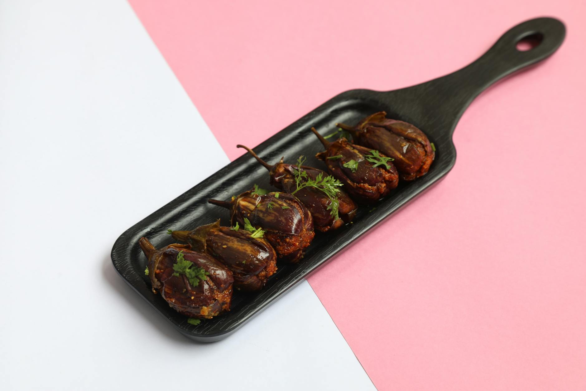 Close-up of Bharli Vangi served on a stylish black platter. Perfect blend of spices and presentation.