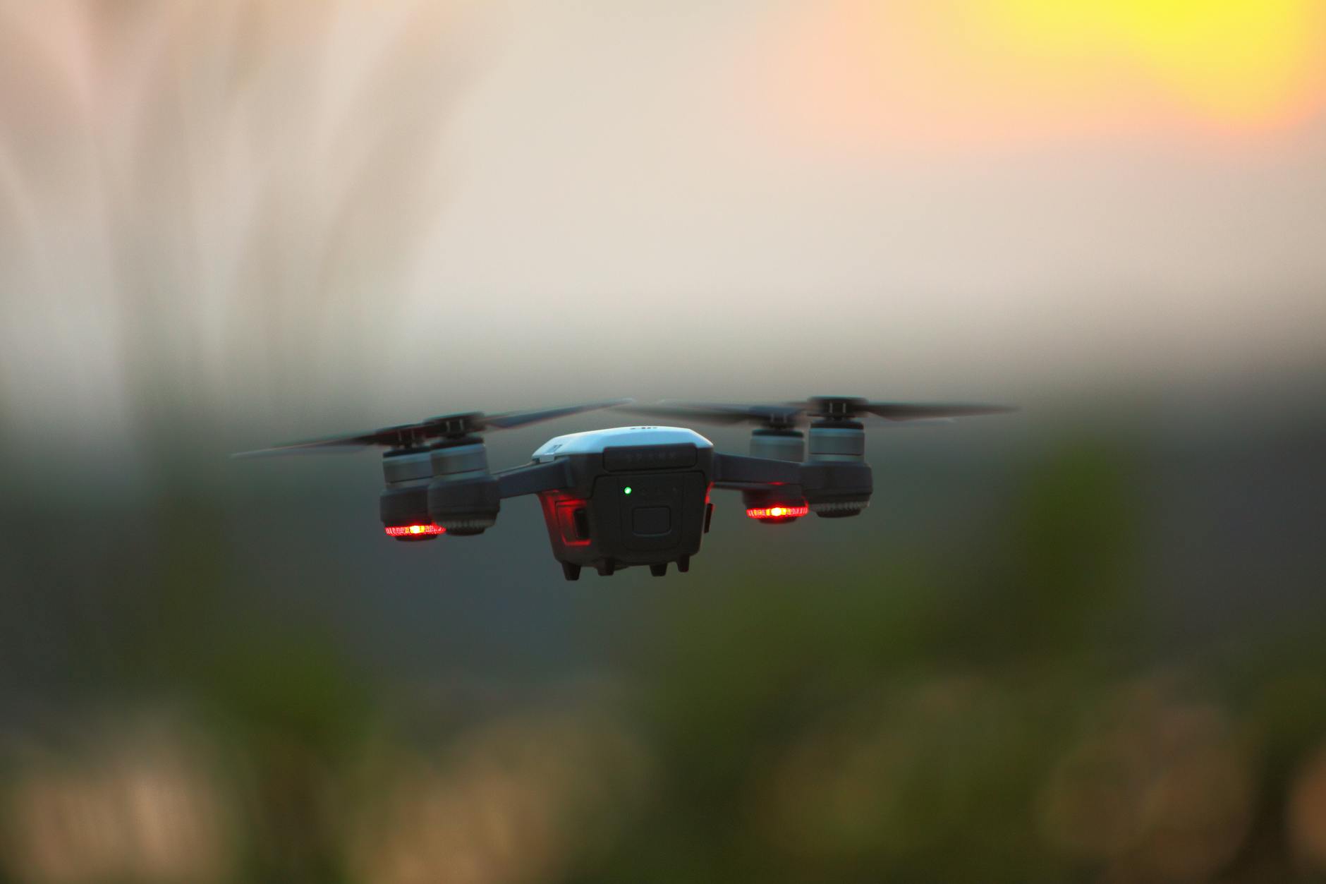 A drone hovering during a vibrant sunset, capturing the tranquil outdoors scene.