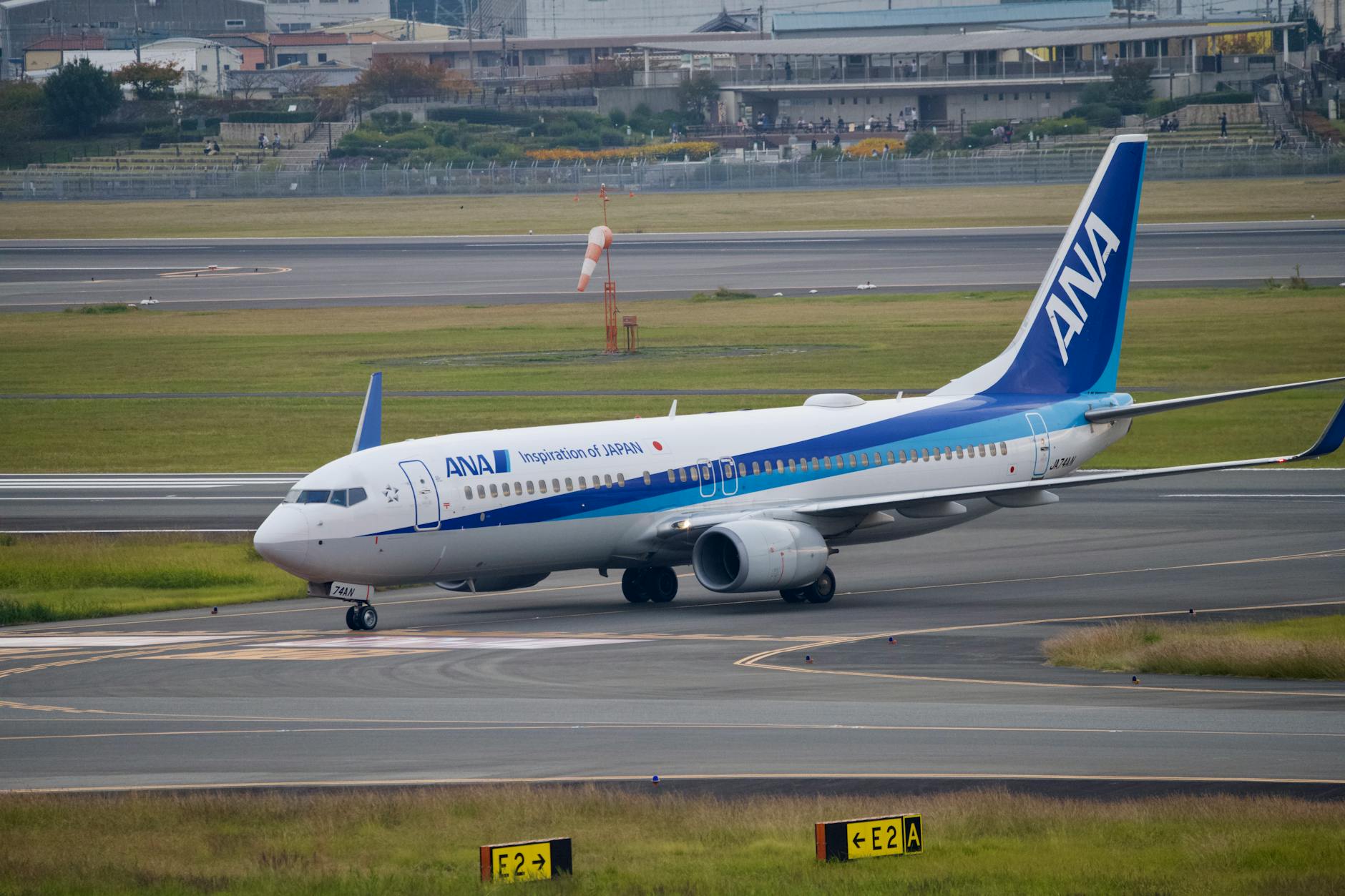 ANA airplane taxiing on runway at a Japanese airport, showcasing aviation travel.