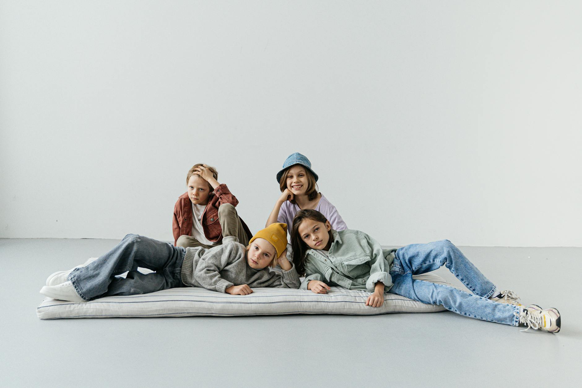 A group of fashionable children posing casually with modern attire, showcasing youthful style.