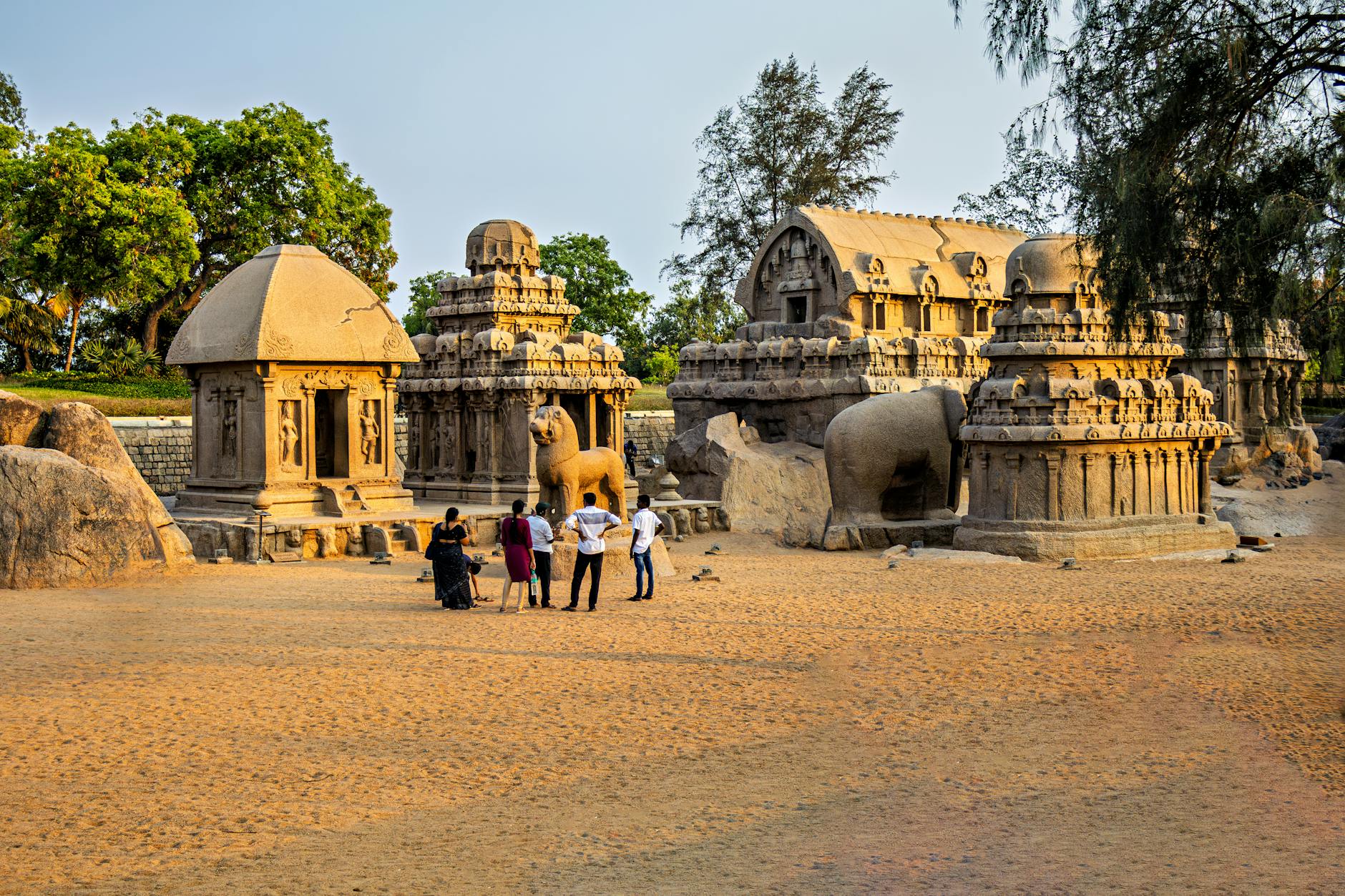 Tourists explore the ancient Pancha Rathas temple complex in Mahabalipuram, India.