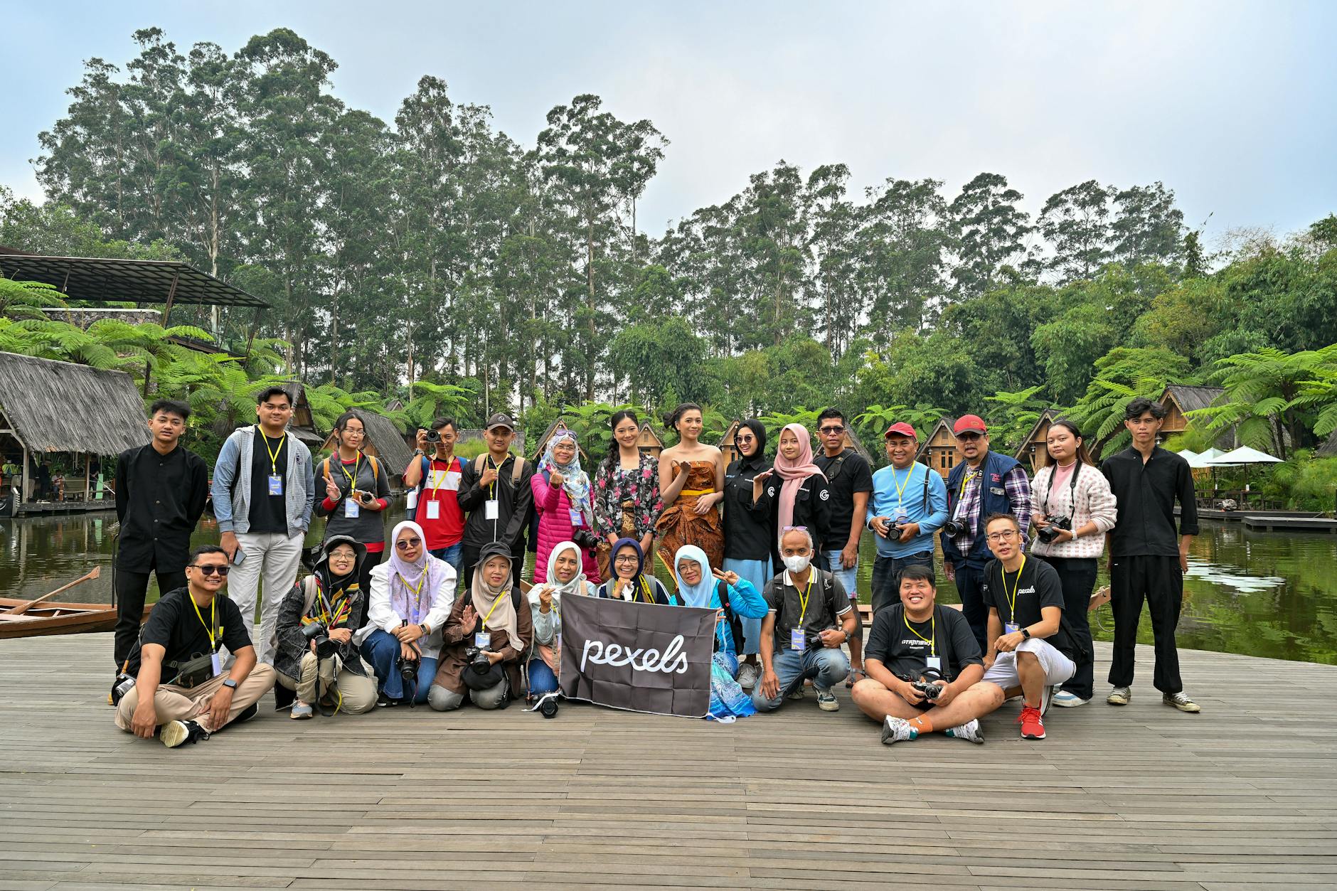 A diverse group of people posing together amidst greenery in Jawa Barat, Indonesia.
