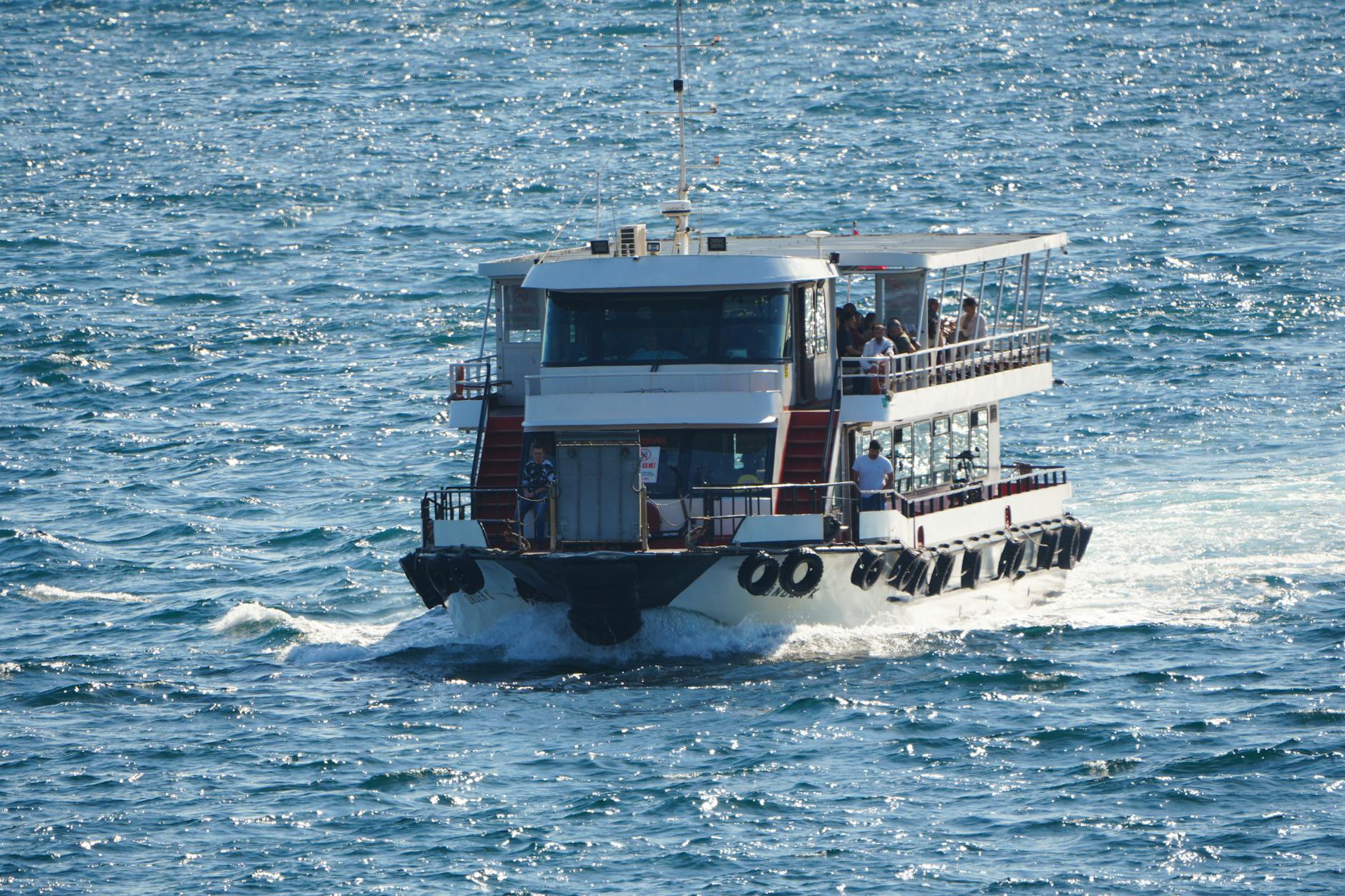 A passenger ferry traveling on the Bosphorus Strait in Istanbul, Türkiye, under clear skies.