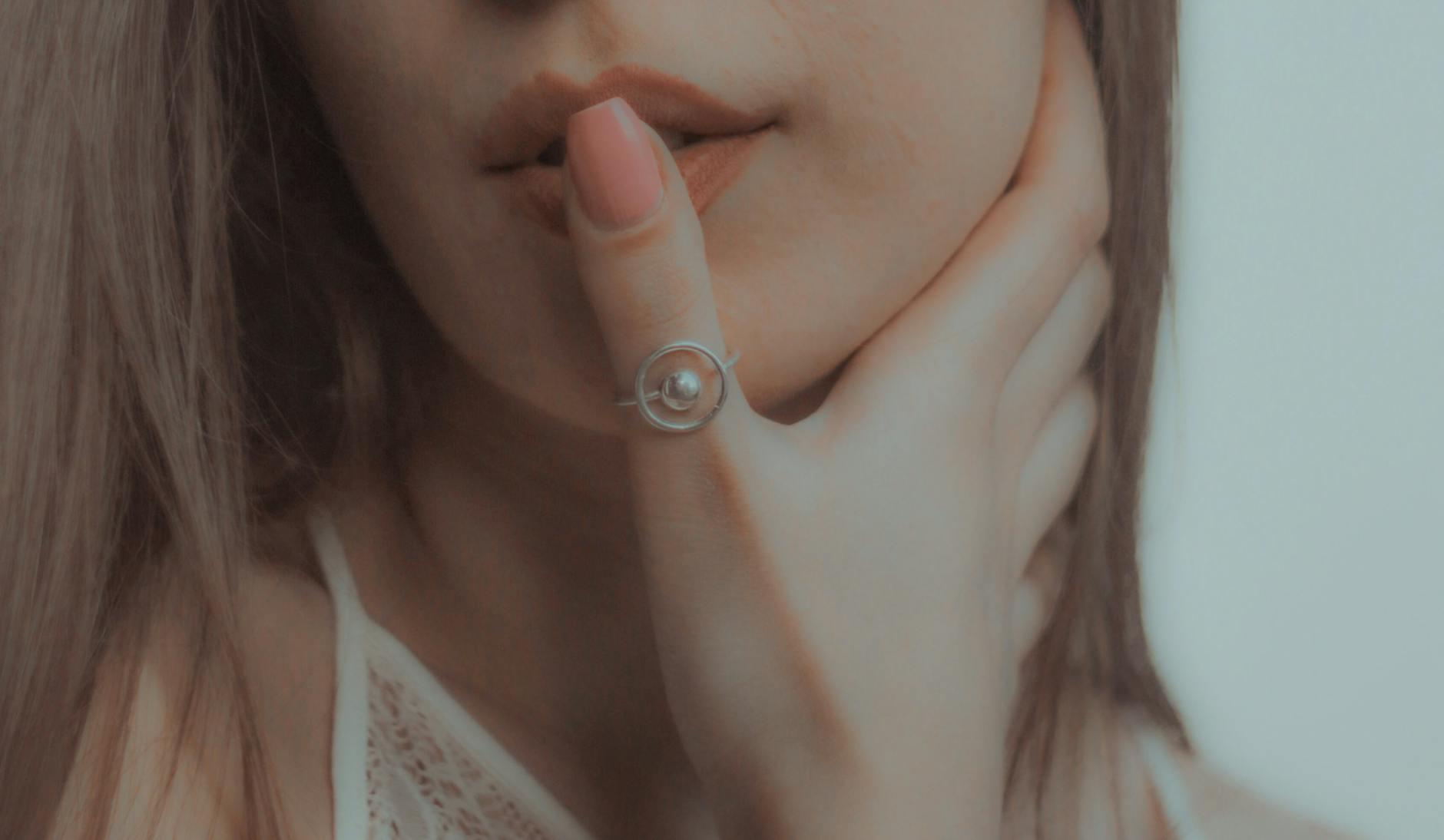 Crop anonymous young female touching face and neck and showing ring on thumb