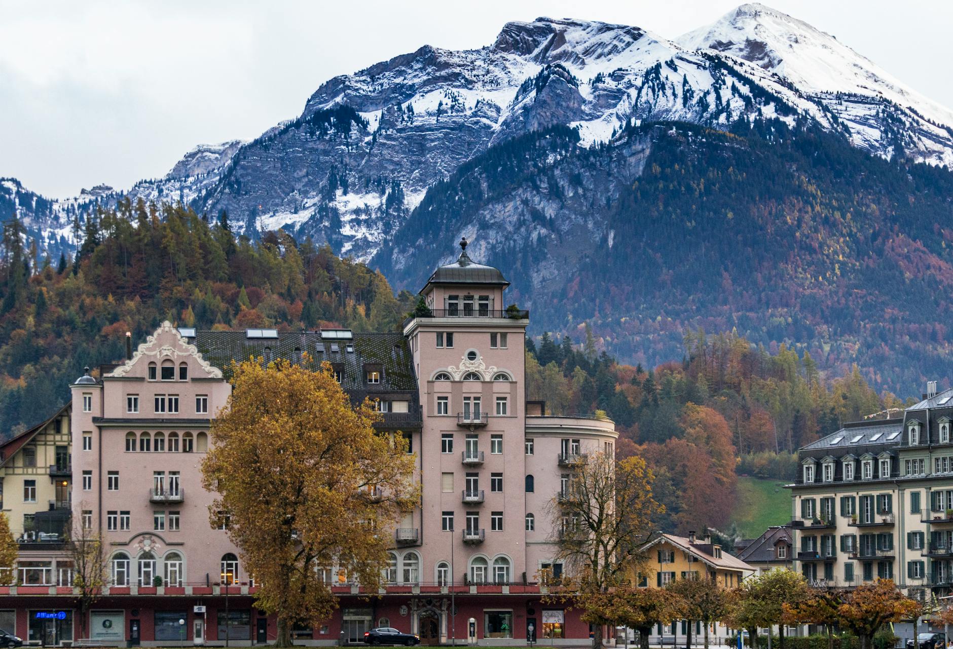 Explore the beauty of Interlaken's architecture against the backdrop of majestic Swiss Alps in autumn.
