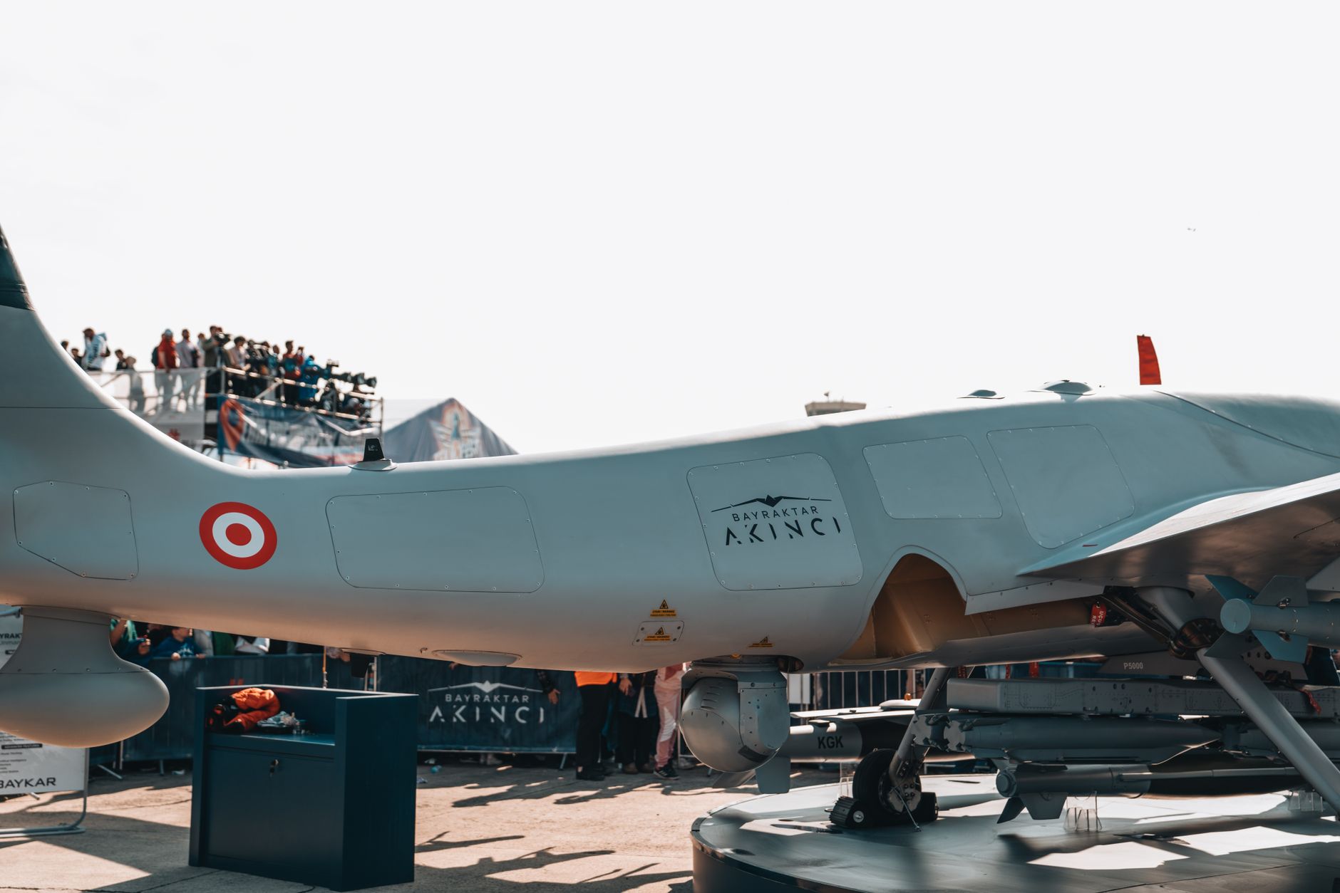 Bayraktar Akinci drone displayed at a busy airshow with spectators.