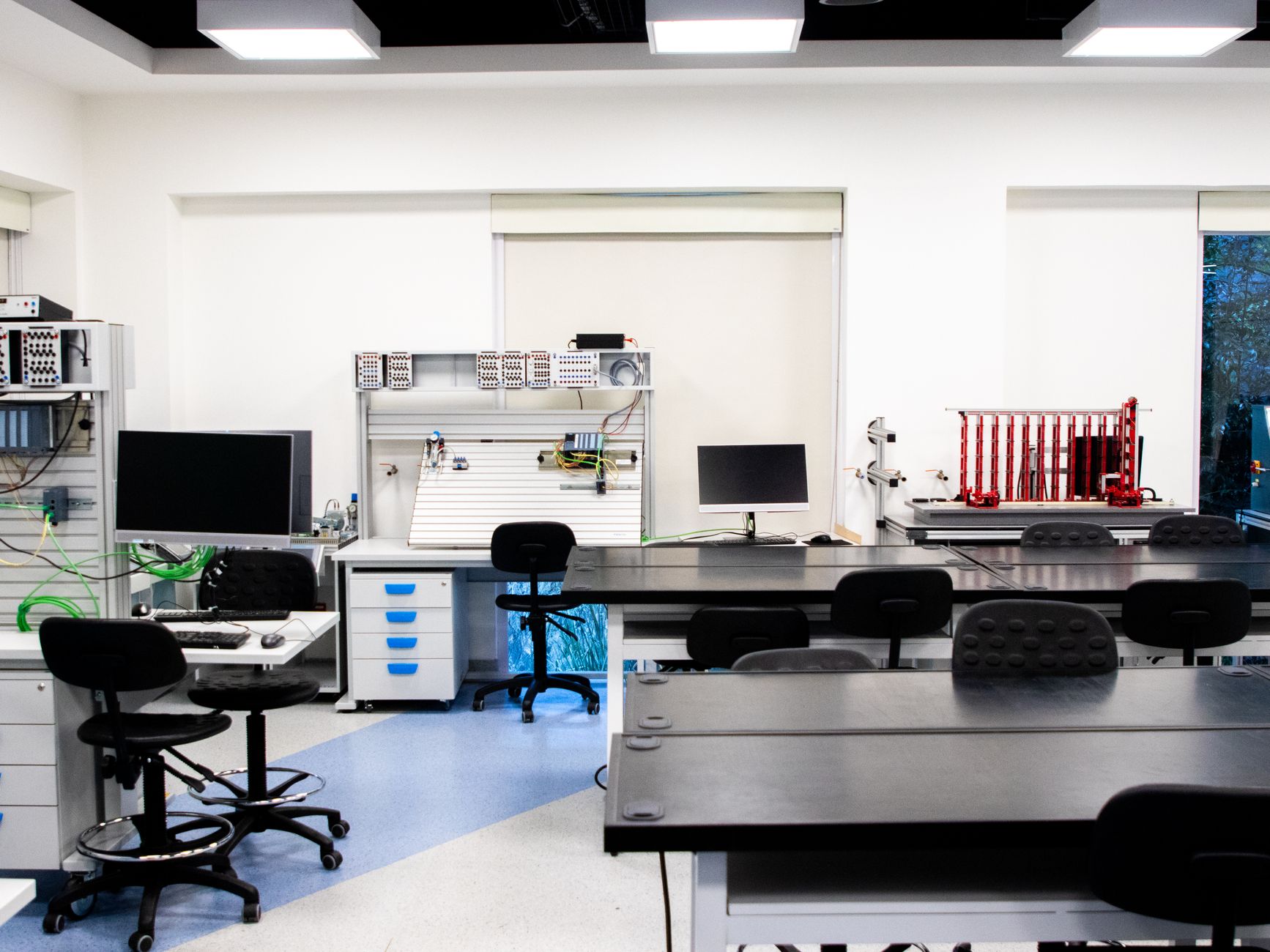 Bright and well-equipped modern technology lab featuring computers, workstations, and desks.