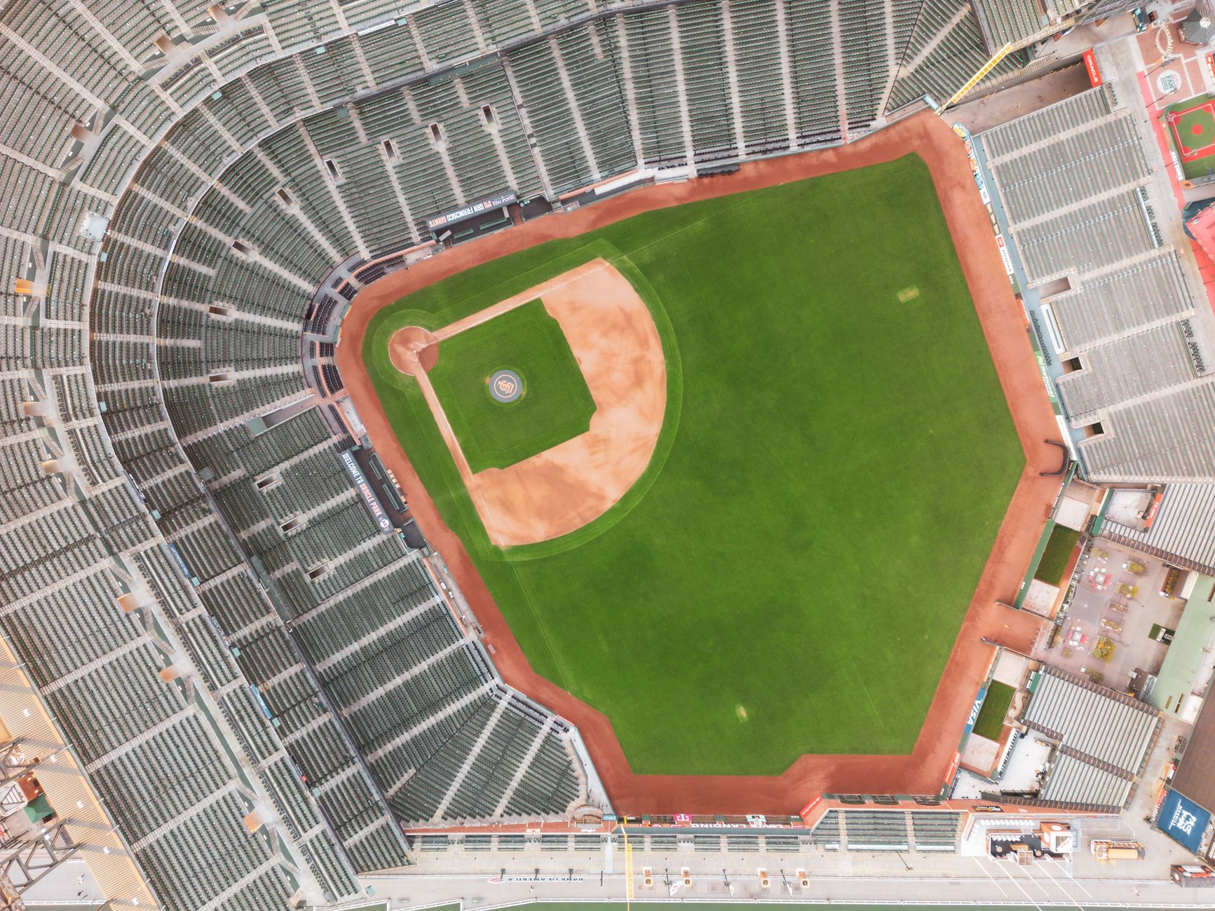 Drone shot capturing a top-down view of an unoccupied baseball stadium.